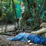 Australian soldiers take cover from 'enemy' fire after taking a prisoner during a raid on an 'enemy' camp during an exercise.