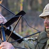 An Army signaller sets up a satellite radio antenna.