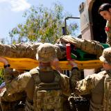 Australian Army soldiers extract a casualty role-player from a vehicle.
