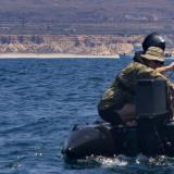 Multinational training participants launch a REMUS 100 autonomous underwater vehicle (AUV).