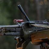 An Australian Army soldier lays down suppressing fire from the hatch of a Protected Mobility Vehicle.