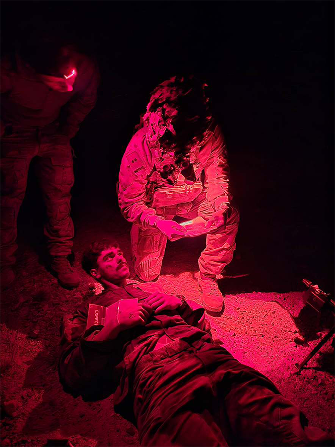 Medical officers treat simulated casualties under tactical conditions